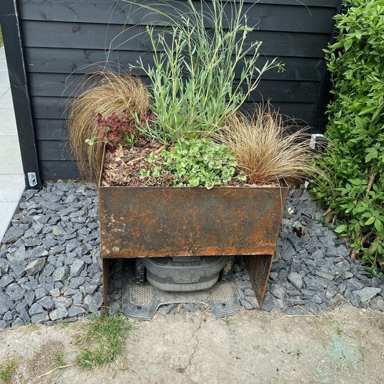 Garasje for robotgressklipper med blomsterbed